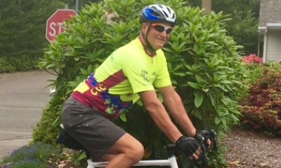 Orthopedic patient Warren Youell riding a bicycle through a neighborhood