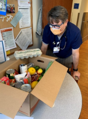 Dr Filuk looking at a box of donated food