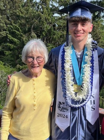 Agnes Wood standing next to grandson in cap and gown for graduation ceremony