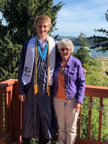 Agnes Wood standing next to grandson in cap and gown for graduation ceremony