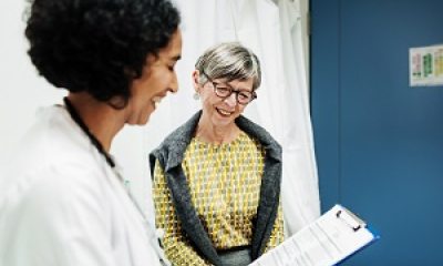 A healthcare provider discusses a chart with a patient in a clinical setting