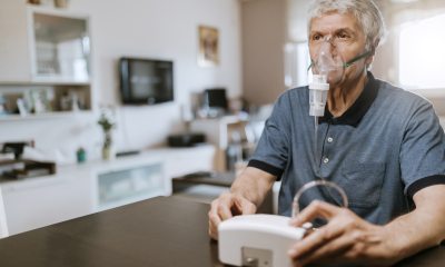 Senior man using an inhaler at home