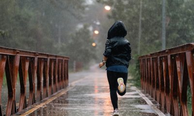 Woman running on a bridge in the rain.