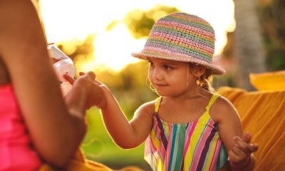 Woman applying sunscreen to young child.