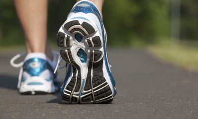 Close-up of bottom of running shoes worn by someone on a path outside