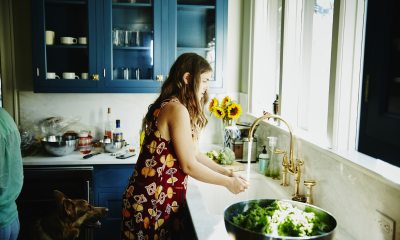 Woman washing her hands at the kitchen sink.