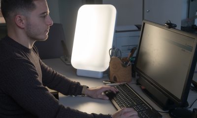 Man working at computer with happiness light next to him.