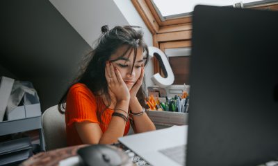 Young woman looking stressed sitting in front of her computer.