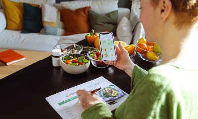 Looking over the shoulder of a redhaired woman using a meal planning app