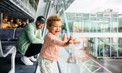 Dad looking at young daughter in airport.