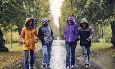 Four adults walking in the rain.