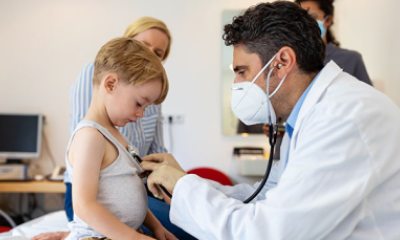 Pediatrician uses stethoscope to listen to little child's heart