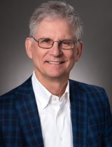 Photo of Bill Dudley in front of a gray background