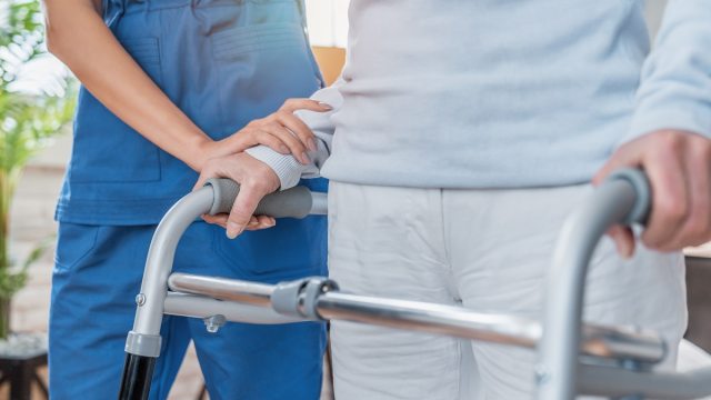 Nurse providing physical therapy to patient.