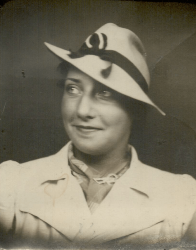 A black and white photograph of a young women wearing a hat.