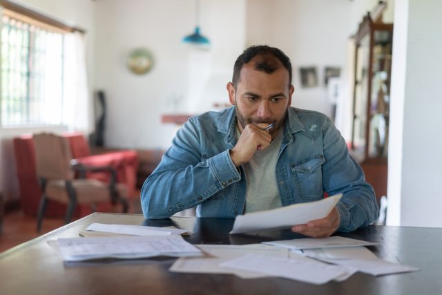 Middle-aged man studies papers at a table