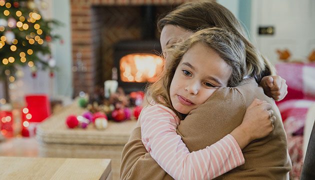 Sad young girl hugging her mom during the holidays