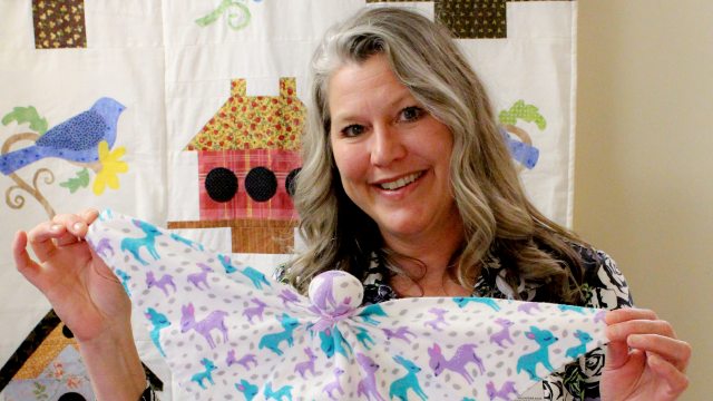 Jill Day holds up a "lovey doll" for NICU families